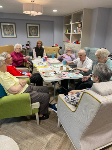 Group of Boclair Care Home residents enjoying an art activity together, surrounded by colourful drawings