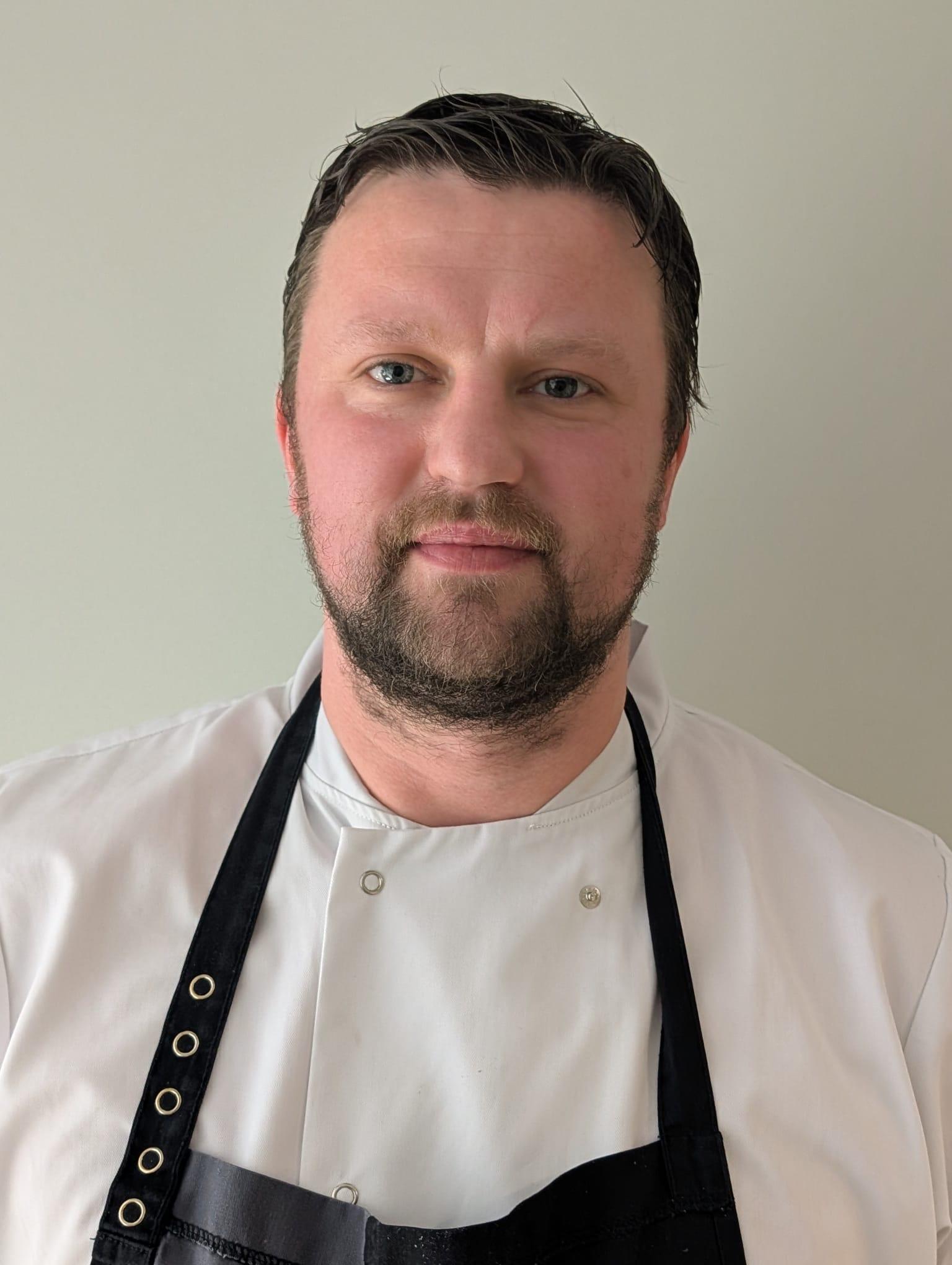 male care home chef in black apron