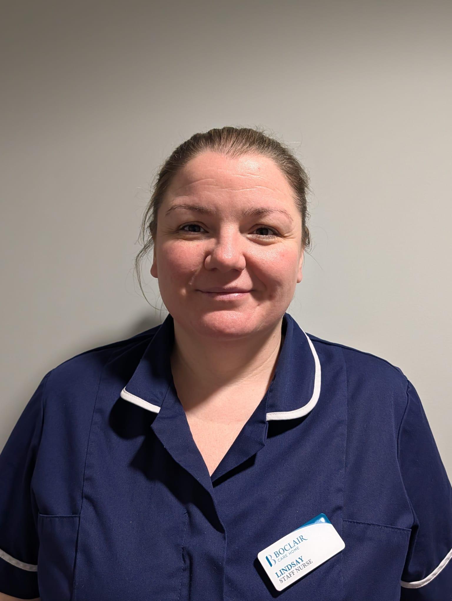 nurse in dark blue uniform smiling