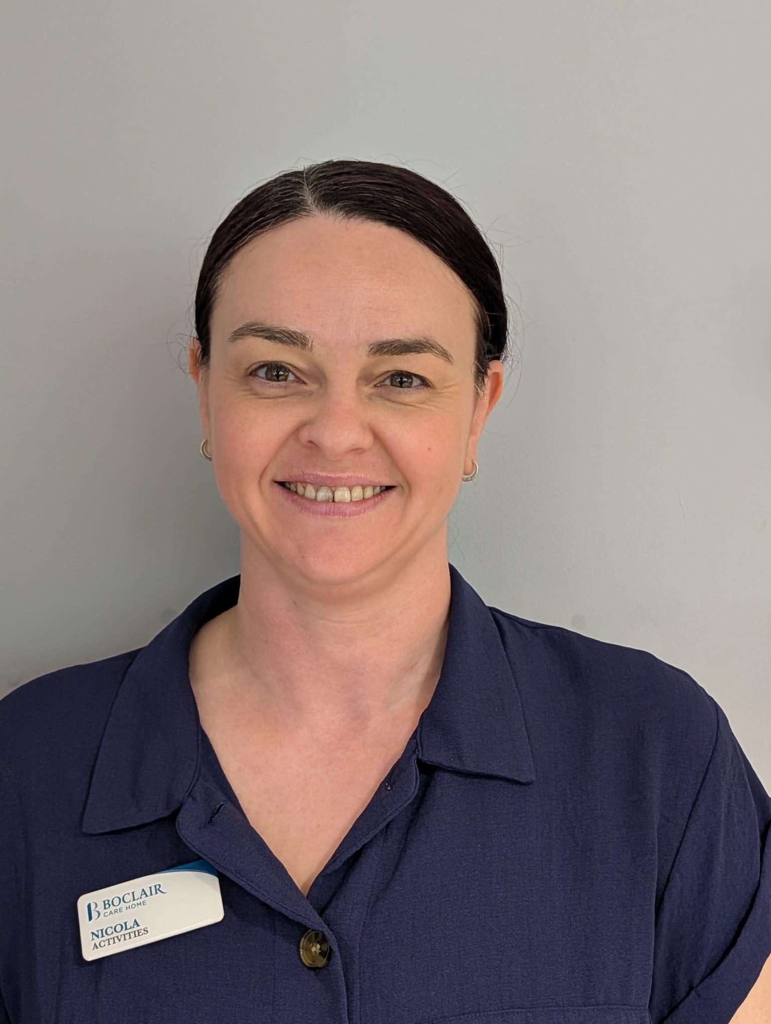 woman with ponytail in dark care home uniform