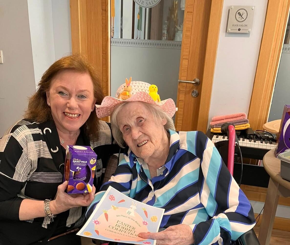 Staff member with resident holding an Easter Egg