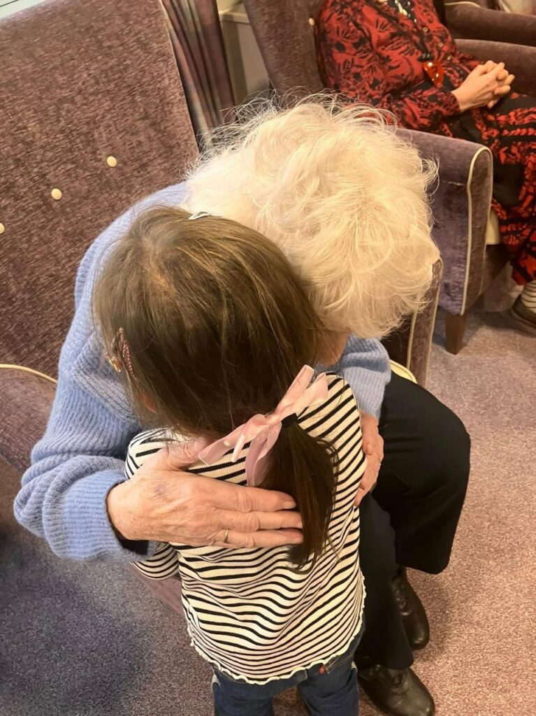 elderly woman hugging young child