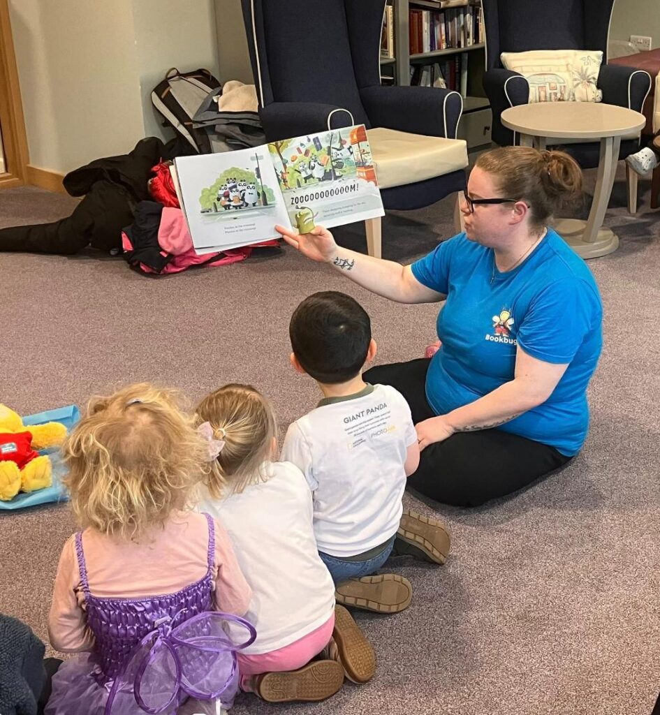 staff member reading picture book to children