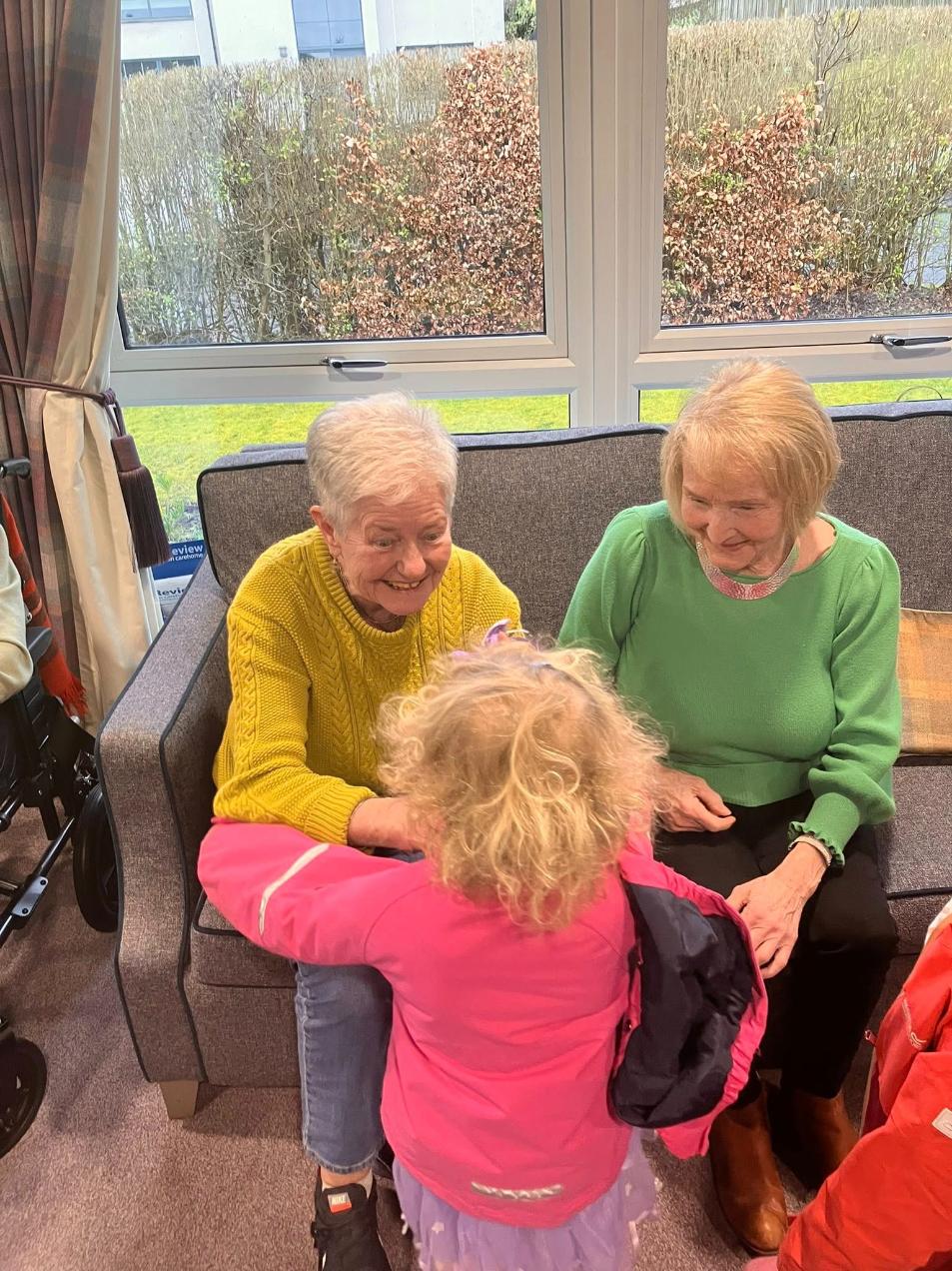 young girl talking to elderly care home residents