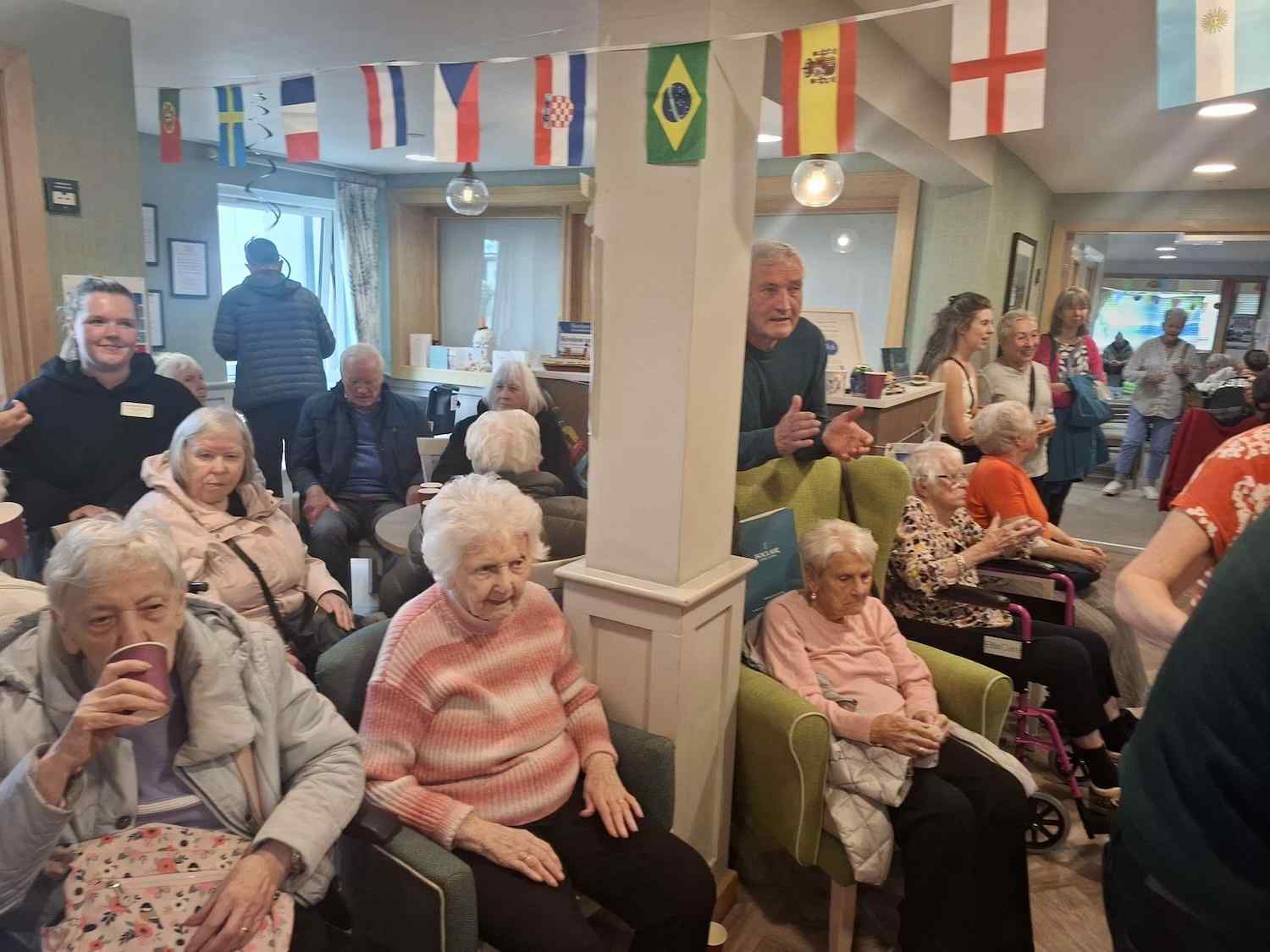 elderly people sitting in a room decorated with world flags